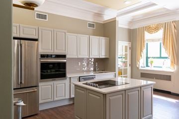 Mattapan apartment for rent - a kitchen with white cabinets and stainless steel appliances