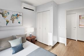 White Plains apartment for rent - a bedroom with a bed and a world map on the wall