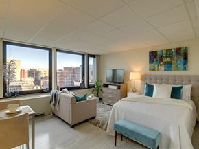 Boston apartment for rent - a bedroom with a bed and a couch and windows