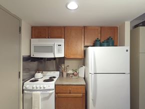 Boston apartment for rent - a kitchen with white appliances and wooden cabinets
