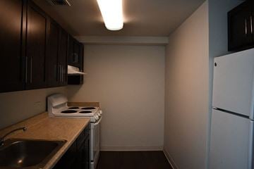 Bronx apartment for rent - a small kitchen with a stove and a refrigerator