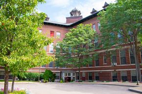 Roxbury apartment for rent - a large red brick building with trees in front of it