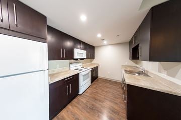 Dorchester apartment for rent - A kitchen with dark wood cabinets and a white fridge.
