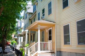 Dorchester townhouse for rent - a row of houses with yellow siding and a porch