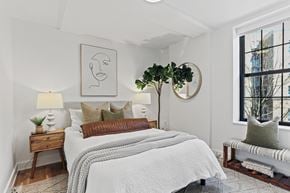 Washington apartment for rent - A bedroom with a large bed and a window overlooking a city.