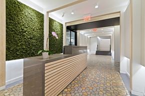 Manhattan apartment for rent - A hallway with a green wall on the left and a wooden reception desk on the right.