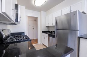 Washington apartment for rent - A kitchen with a stove top oven and a refrigerator.