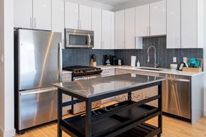 Boston apartment for rent - a modern kitchen with stainless steel appliances and white cabinets