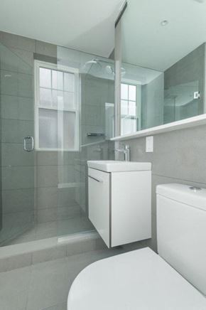 Brighton apartment for rent - A white toilet sits next to a white cabinet in a bathroom.