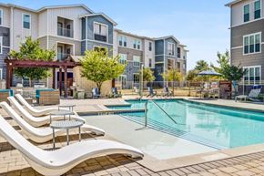 Kyle apartment for rent - our apartments offer a swimming pool with lounge chairs and tables