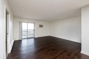 Quincy apartment for rent - an empty living room with wood flooring and a balcony