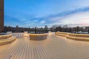 New York apartment for rent - A wooden deck with a curved railing and benches.
