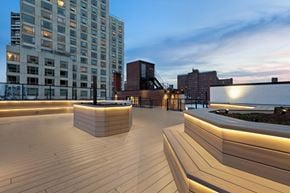 New York apartment for rent - A wooden deck with a bench and a building in the background.
