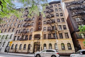 Manhattan apartment for rent - A silver car is parked in front of a building with a yellow sign.