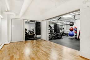 Manhattan apartment for rent - A gym with a mirrored wall and wooden floors.