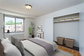 Washington apartment for rent - A bedroom with a large bed and a window overlooking a building.