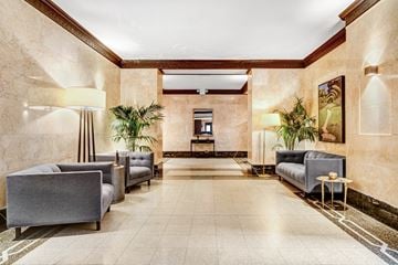 Manhattan apartment for rent - A spacious waiting area with grey couches and plants.