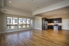 Boston apartment for rent - an empty living room with wood floors and a kitchen