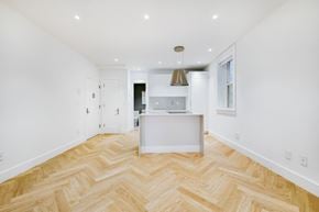 Brooklyn apartment for rent - A kitchen with a white island and a herringbone patterned floor.
