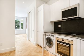 Brooklyn apartment for rent - A kitchen with white cabinets and a black microwave.