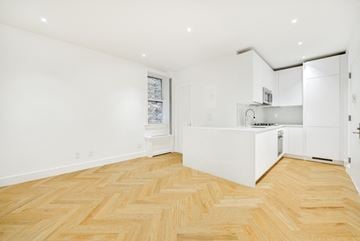 Brooklyn apartment for rent - A kitchen with white cabinets and a wooden floor.