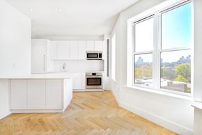 Brooklyn apartment for rent - A kitchen with white cabinets and a wooden floor.