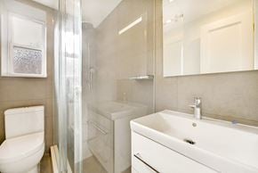 Brooklyn apartment for rent - A white toilet sits next to a white sink in a bathroom.