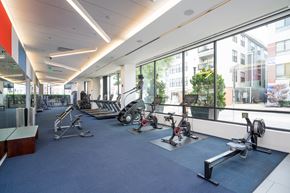 Boston apartment for rent - a gym with weights and exercise equipment in a building with large windows