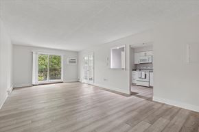 Warrington apartment for rent - A spacious room with wooden flooring and white walls.