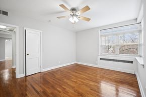 Philadelphia apartment for rent - A room with a ceiling fan and wooden floors.