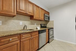 Warrington apartment for rent - A kitchen with brown cabinets and a granite countertop.