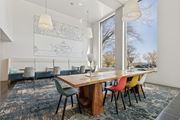 King Of Prussia apartment for rent - Bright and stylish west lobby at 251 Dekalb Apartments in King of Prussia, PA, featuring a communal wood table with colorful chairs, oversized pendant lights, and wall art—ideal for resident gathering or remote work.