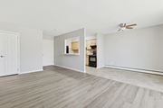 Norristown apartment for rent - A room with a white ceiling and a wooden floor with a breakfast window looking into the kitchen.