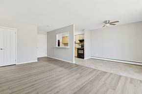 Norristown apartment for rent - A room with a white ceiling and a wooden floor with a breakfast window looking into the kitchen.