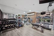 Philadelphia apartment for rent - A gym with a variety of equipment including dumbbells, weight plates, and a bench press.