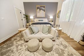 Lansdale apartment for rent - A bedroom with a bed, two lamps, a painting, and a white couch.