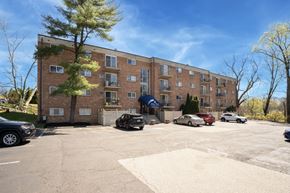 Elkins Park apartment for rent - A parking lot in front of a brick apartment building.