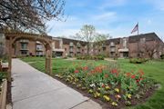 Philadelphia apartment for rent - A garden with a variety of flowers in the foreground and apartment buildings in the background.