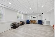 Philadelphia apartment for rent - A spacious room with a white ceiling and wooden flooring, furnished with a TV, a couple of chairs, and a table.