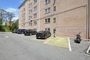 Philadelphia apartment for rent - A parking lot with cars and a motorcycle in front of a brick building.
