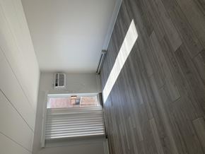 Elkins Park apartment for rent - an air conditioning unit sits on a wooden floor in a room with white walls and wood floors