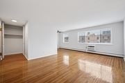 Philadelphia apartment for rent - A room with wooden floors and a large window with a view of a building.