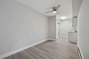 Philadelphia apartment for rent - A room with a ceiling fan and light fixture, and a cabinet with a yellow object on top.