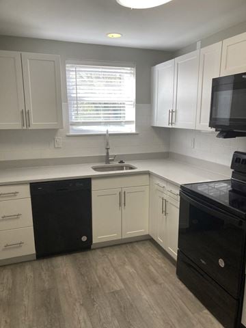 Norristown apartment for rent - a kitchen with white cabinets and a sink and a window