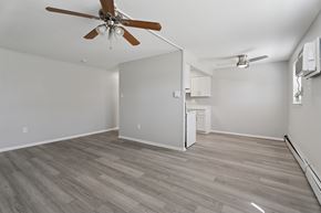 Roslyn apartment for rent - A room with a ceiling fan and a refrigerator.