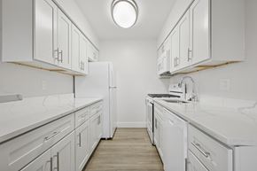Landsdale apartment for rent - A white kitchen with a refrigerator, stove, and sink.