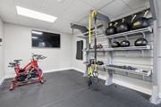 Landsdale apartment for rent - A gym room with a red bike, a yellow pull up bar, and black weight plates.