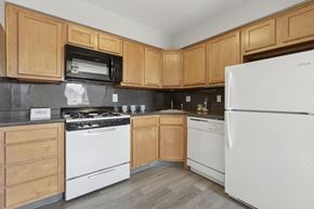 Warrington apartment for rent - A kitchen with wooden cabinets and white appliances.