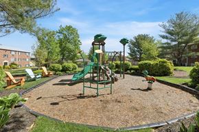 Warrington apartment for rent - A playground with a green slide and a red and yellow swing set.