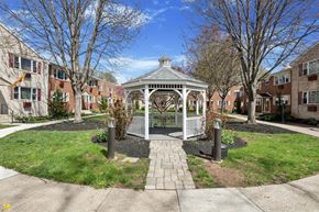Norristown apartment for rent - A gazebo is surrounded by a small garden and a metal fence.